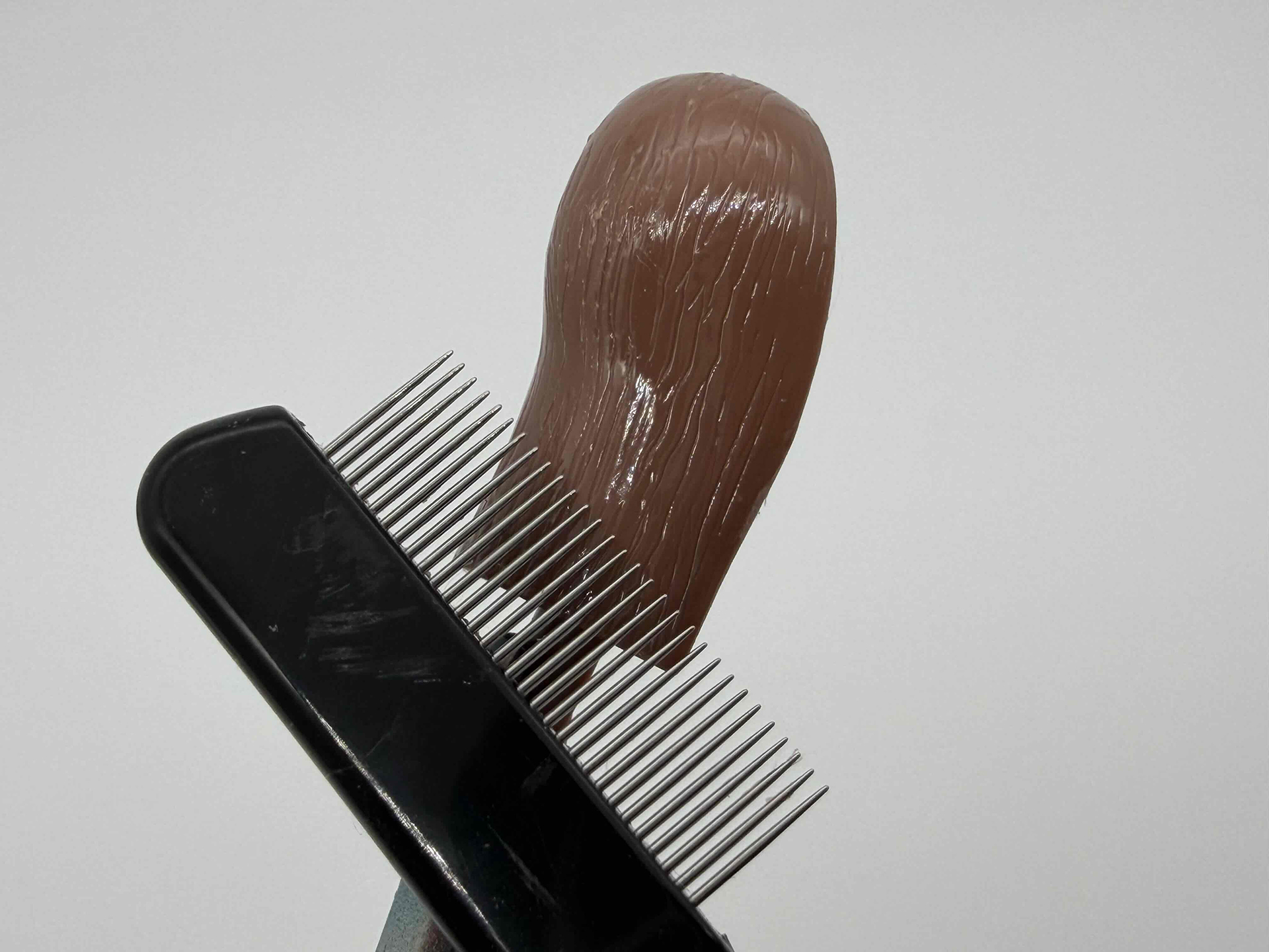 タミヤセメントを塗って表面が溶け出したらマスカラコームで毛の流れをつくっていきます