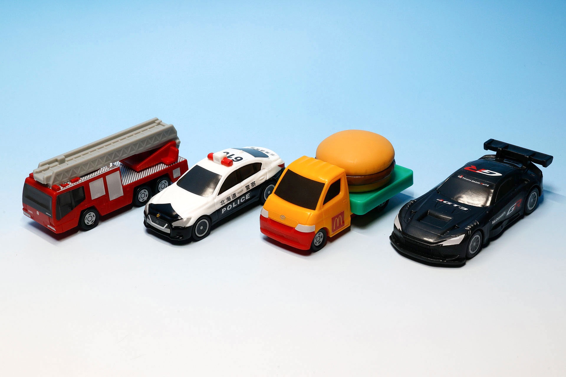 こちらが第1弾（4月10日〜4月23日）のハッピーセット「トミカ」に登場するおもちゃ。写真左から「日野はしご付き消防車（モリタ・スーパージャイロラダー）」、「トヨタ タウンエース ハンバーガーカー」、「日産 スカイライン パトロールカー」、「GR GT3」