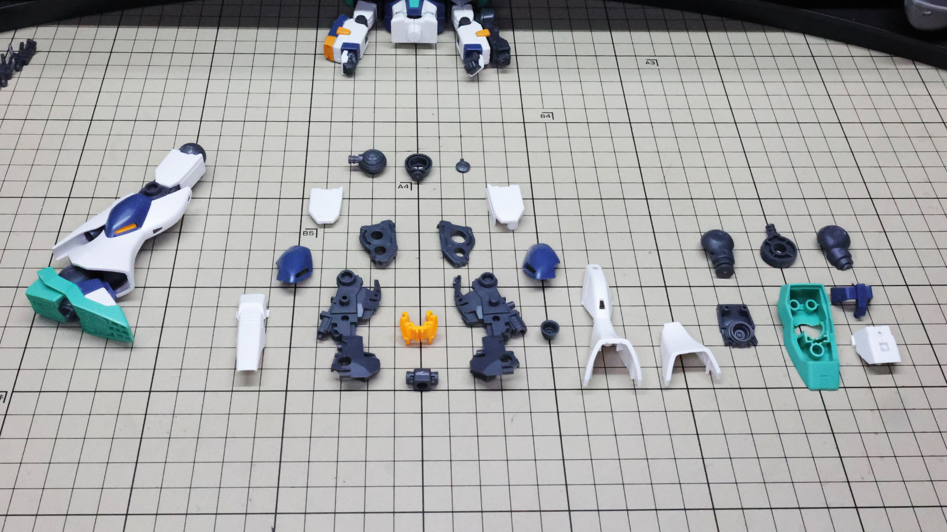 右脚を組んであります。中央にメカフレームが目立つ脚部本体、右にソールのパーツ群です