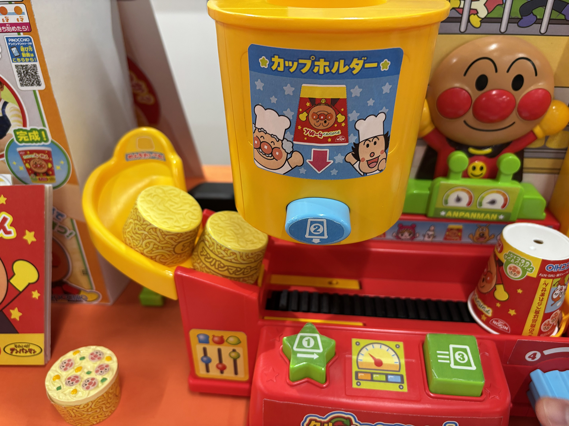 緑の星形のボタンを押すとロックが外れ、カップホルダーの下に麺が移動する