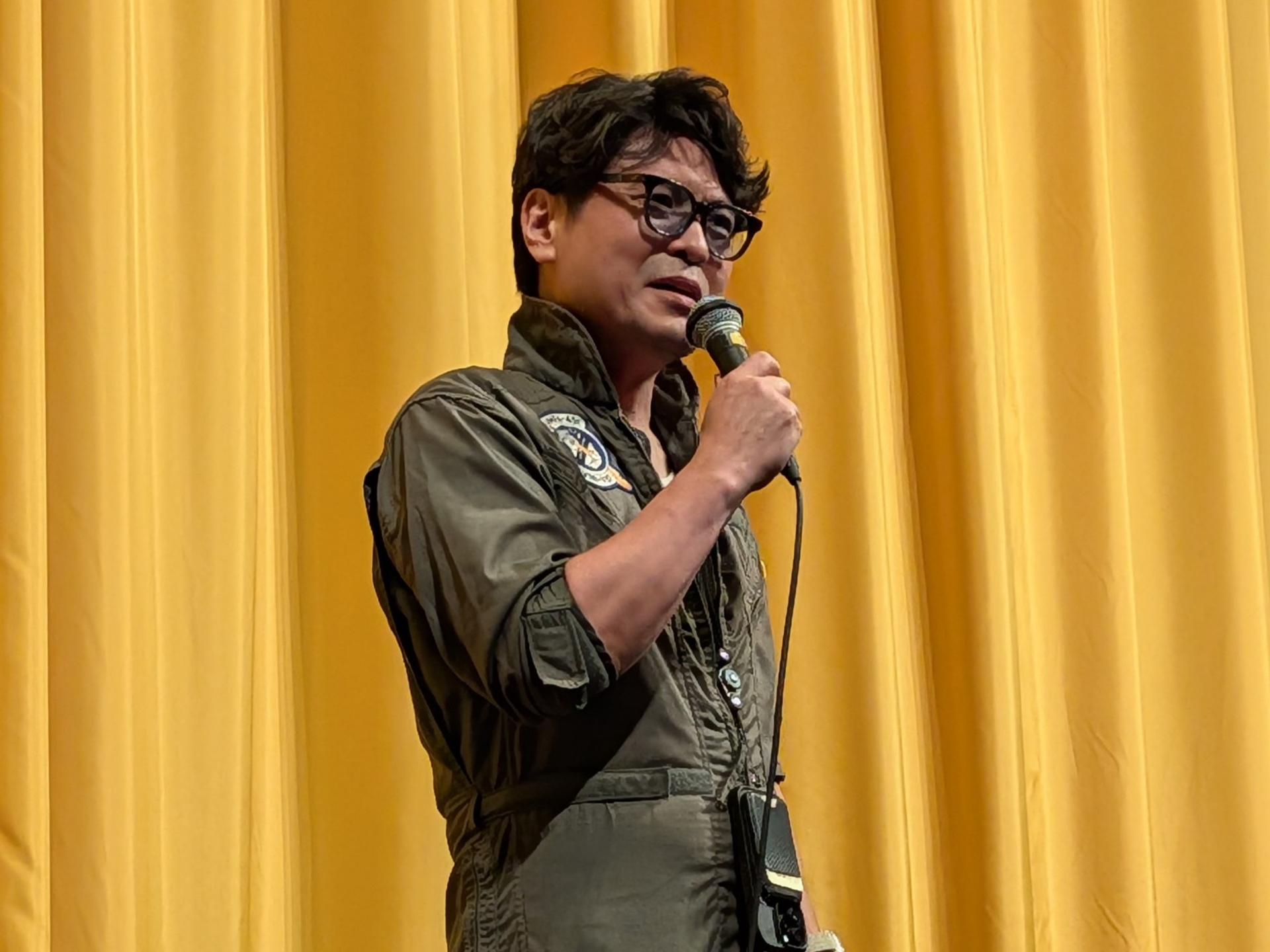 新谷かおる氏のトーク相手となるもう1人のゲスト、天神英貴氏は友達からもらったという本物の米軍のユニフォームで登場