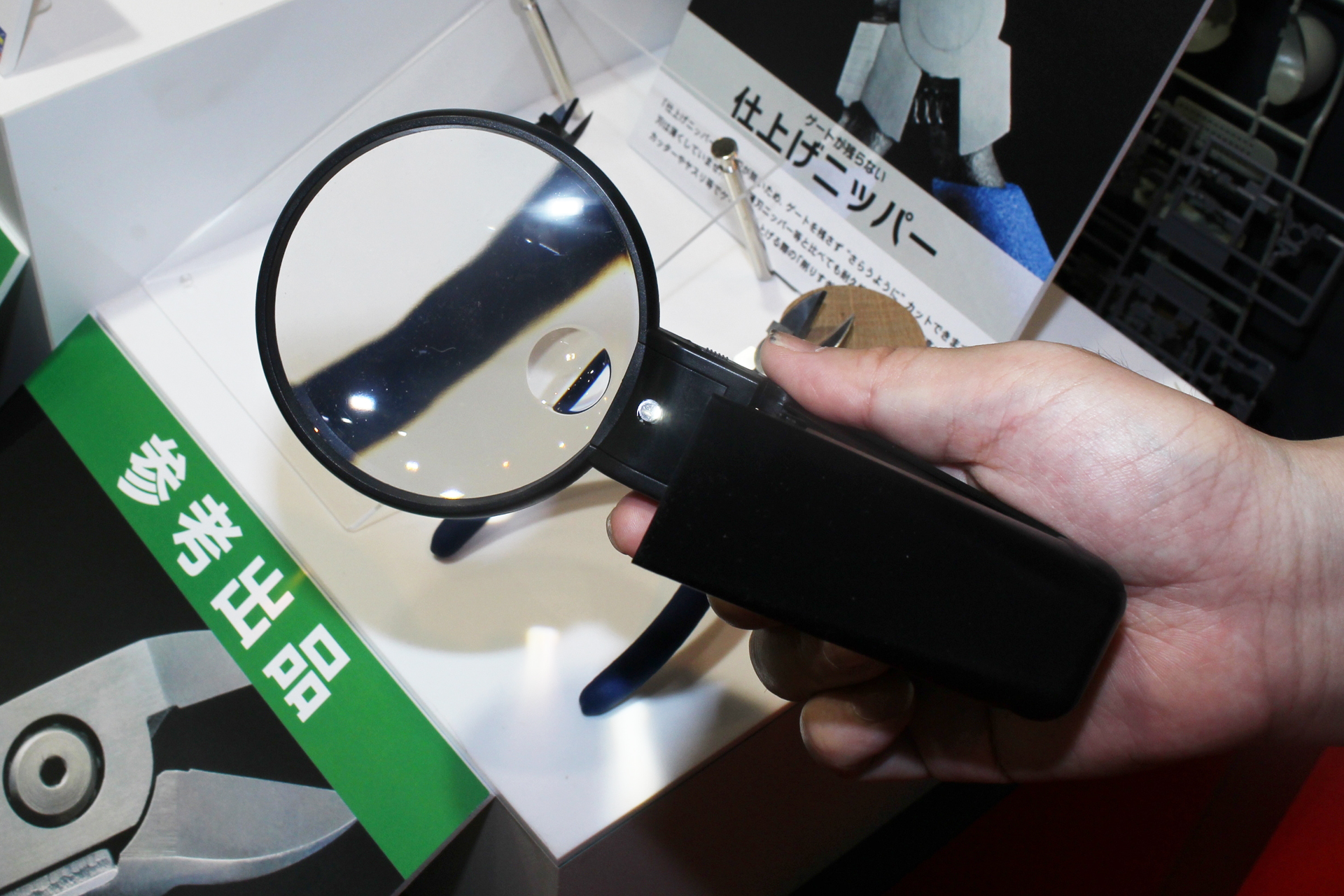 グリップ部分に折り畳み式のスタンドを内蔵。畳むと小さくなるので収納も楽だ。レンズの下側に4倍のレンズがある