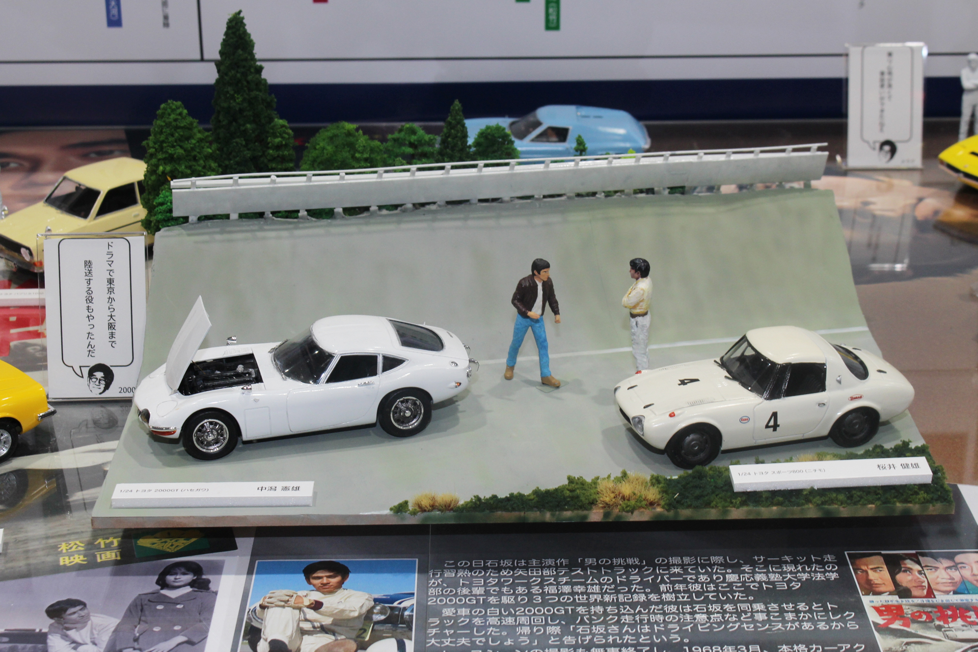 福澤さんと石坂さんのコース上での運命的な出会いをジオラマで表現した中潟氏の作品。左の「トヨタ2000GT」が福澤さんの車で、石坂さんはそれに同乗してコースの走り方を教わったそうだ。右の「トヨタスポーツ800」は、劇中で石坂さんが乗った車