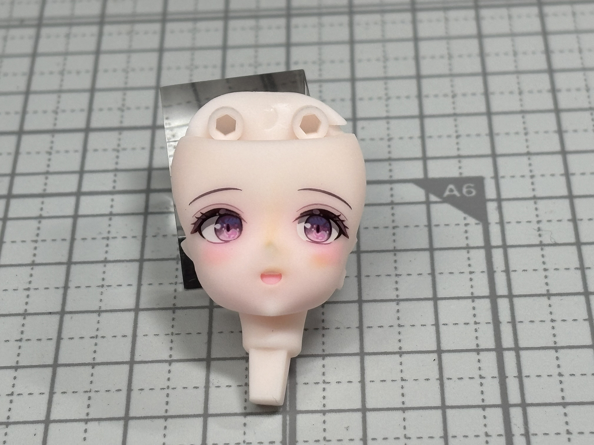 頬のチークをピンクで強調、アイボリーで鼻筋を際立たせる