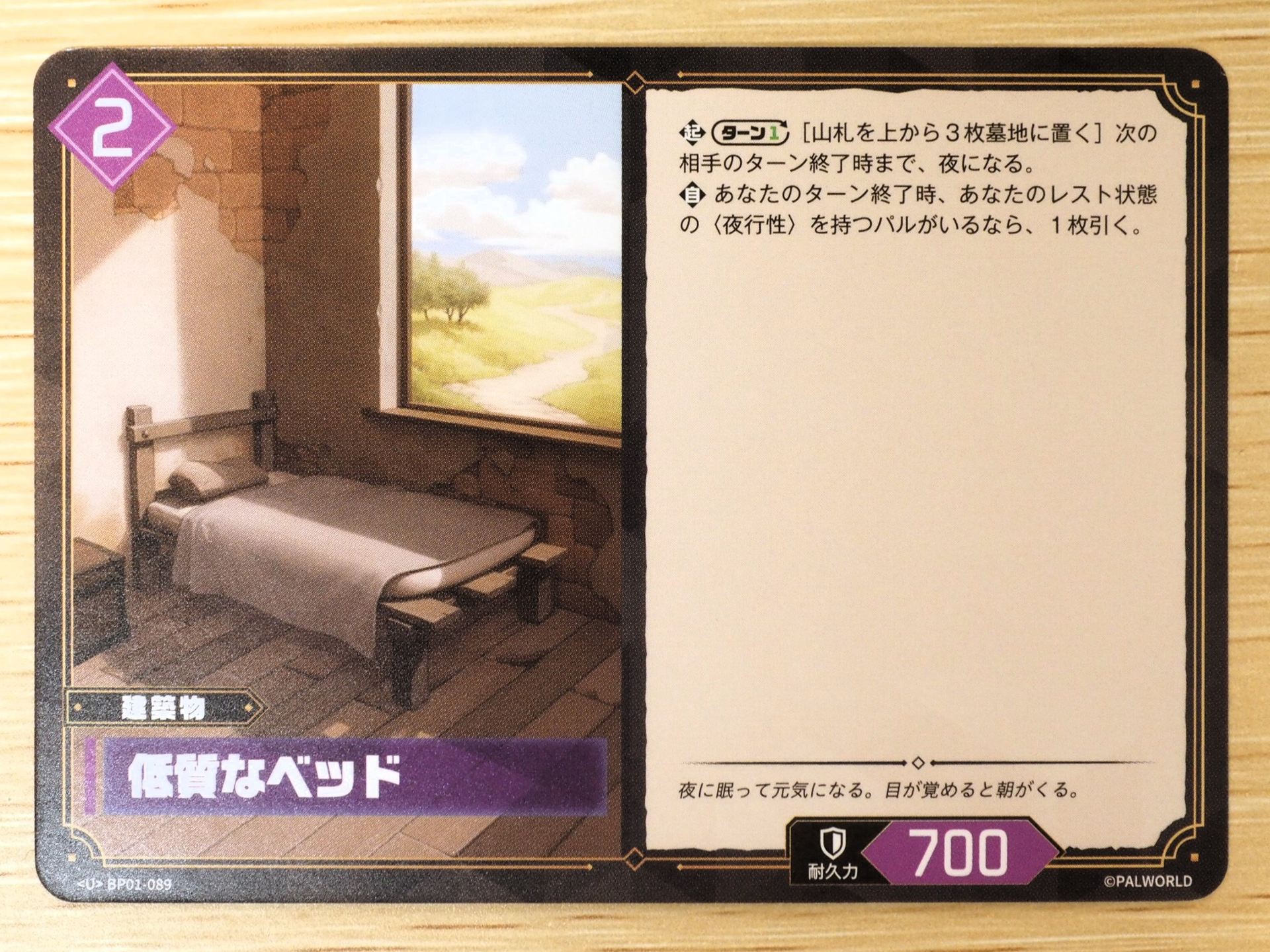 紫2コストの「建築物カード: 低質なベッド」。レアリティはU。ターンに1回、山札の上から3枚を墓地に置くことで、次の相手のターン終了時まで夜になる。また、ターン終了時にレスト状態の<夜行性>を持つパルがいるなら1枚引く