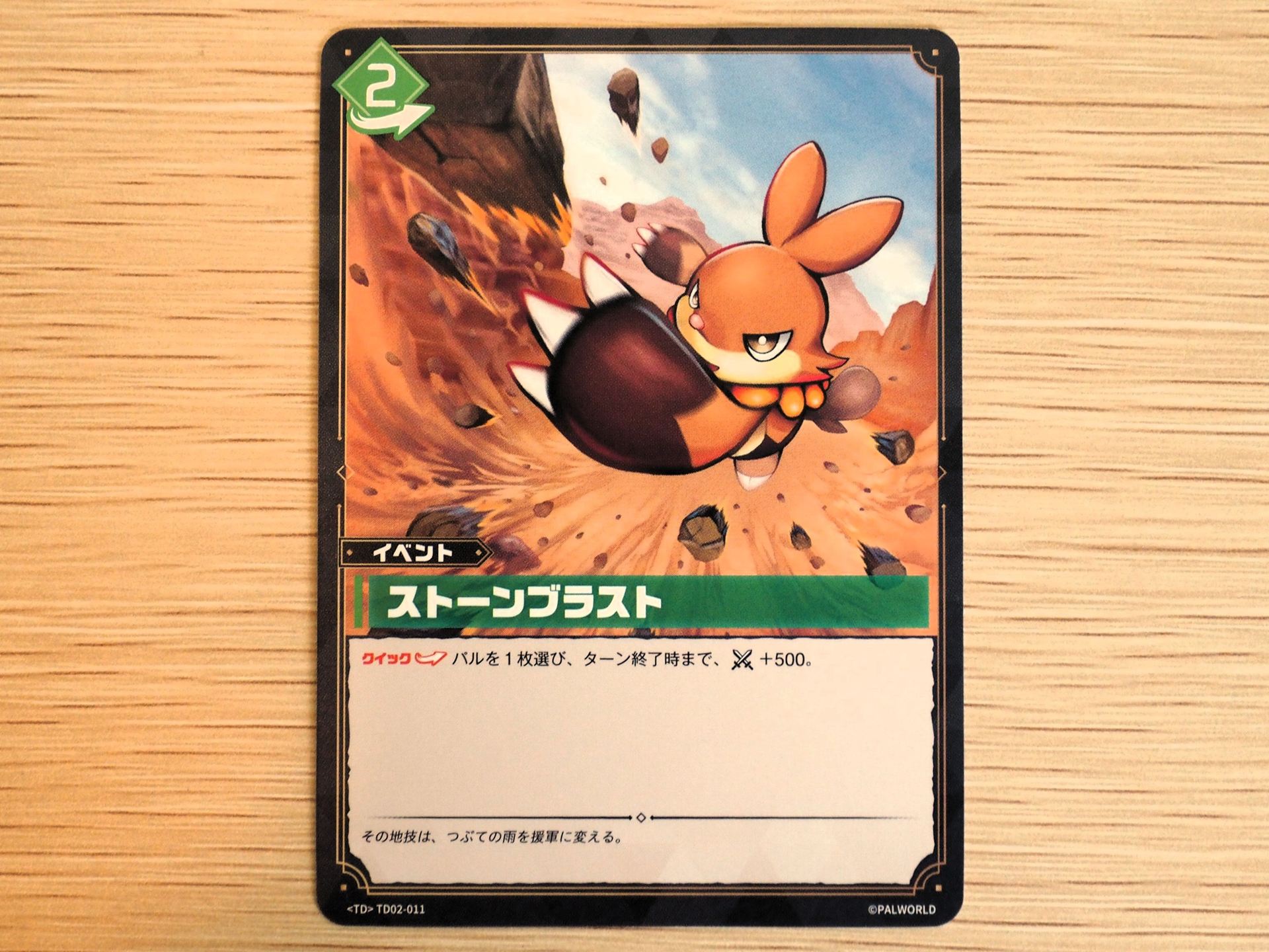 緑2コストの「イベントカード: ストーンブラスト」。『クイック』を持っており、相手のターンでも利用できる。パルを1枚選んで、ターン終了時まで戦闘力を＋500できる