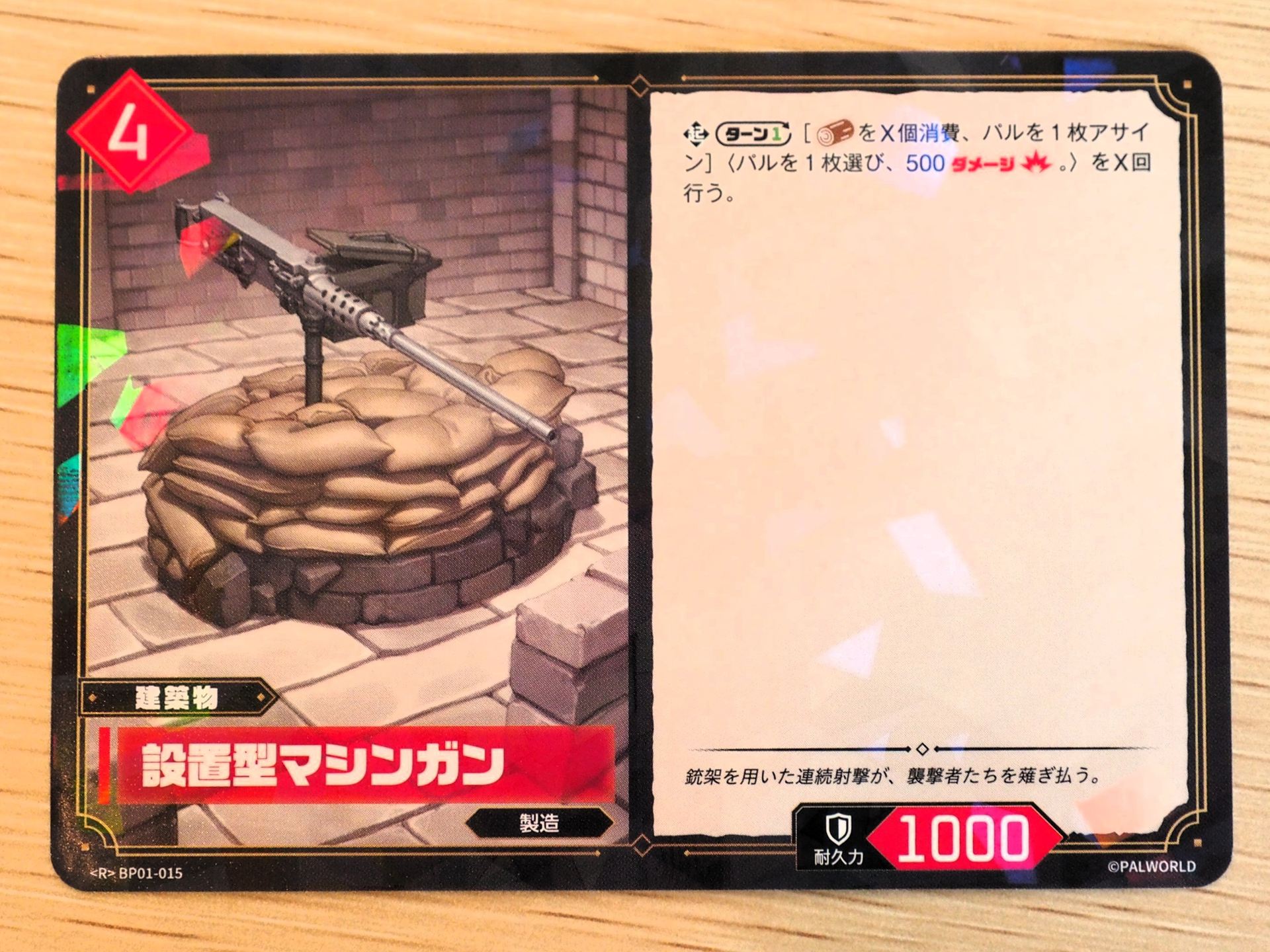 赤4コストの「建築物カード: 設置型マシンガン」。レアリティはR。ターンに1回、『素材』をX個消費し、パルを1枚アサインすることで、「パルを1枚選び、500ダメージを与える」をX回行なう
