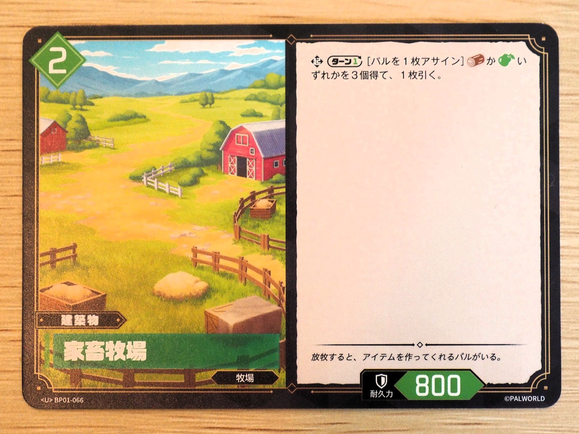 緑2コストの「建築物カード: 家畜牧場」。レアリティはU。ターンに1回、パルを1枚アサインすることで、『素材』か『食材』のいずれかを3個得て、1枚引く
