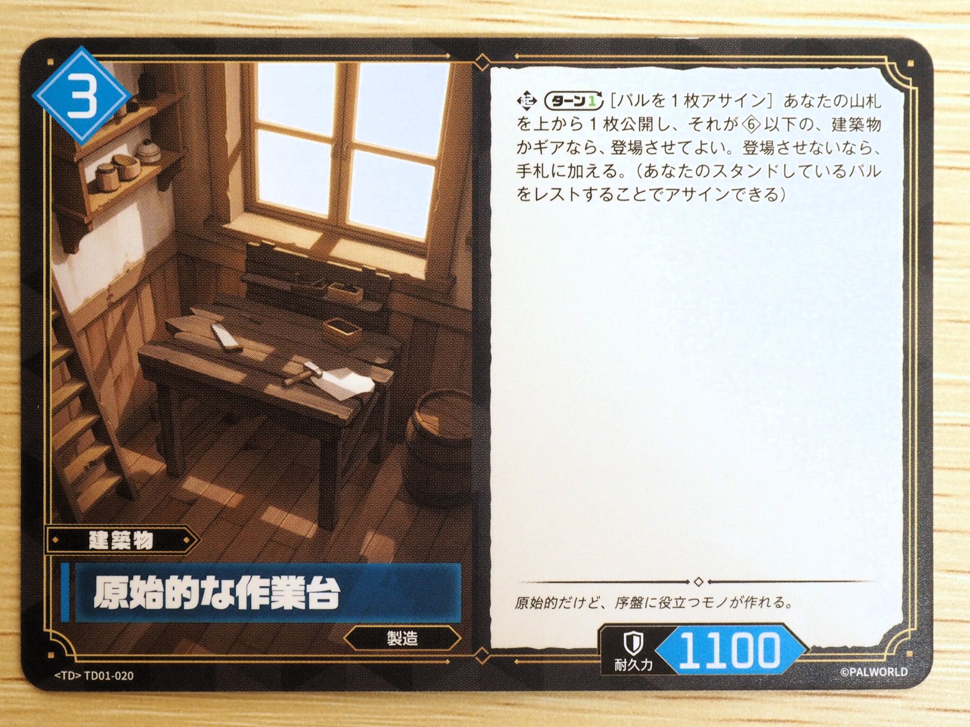 青3コストの「建築物カード: 原始的な作業台」。ターンに1回、パルを1枚アサインすることで、山札の上から1枚を公開し、それがコスト6以下の建築物かギアなら登場させてよい。登場させないなら手札に加える