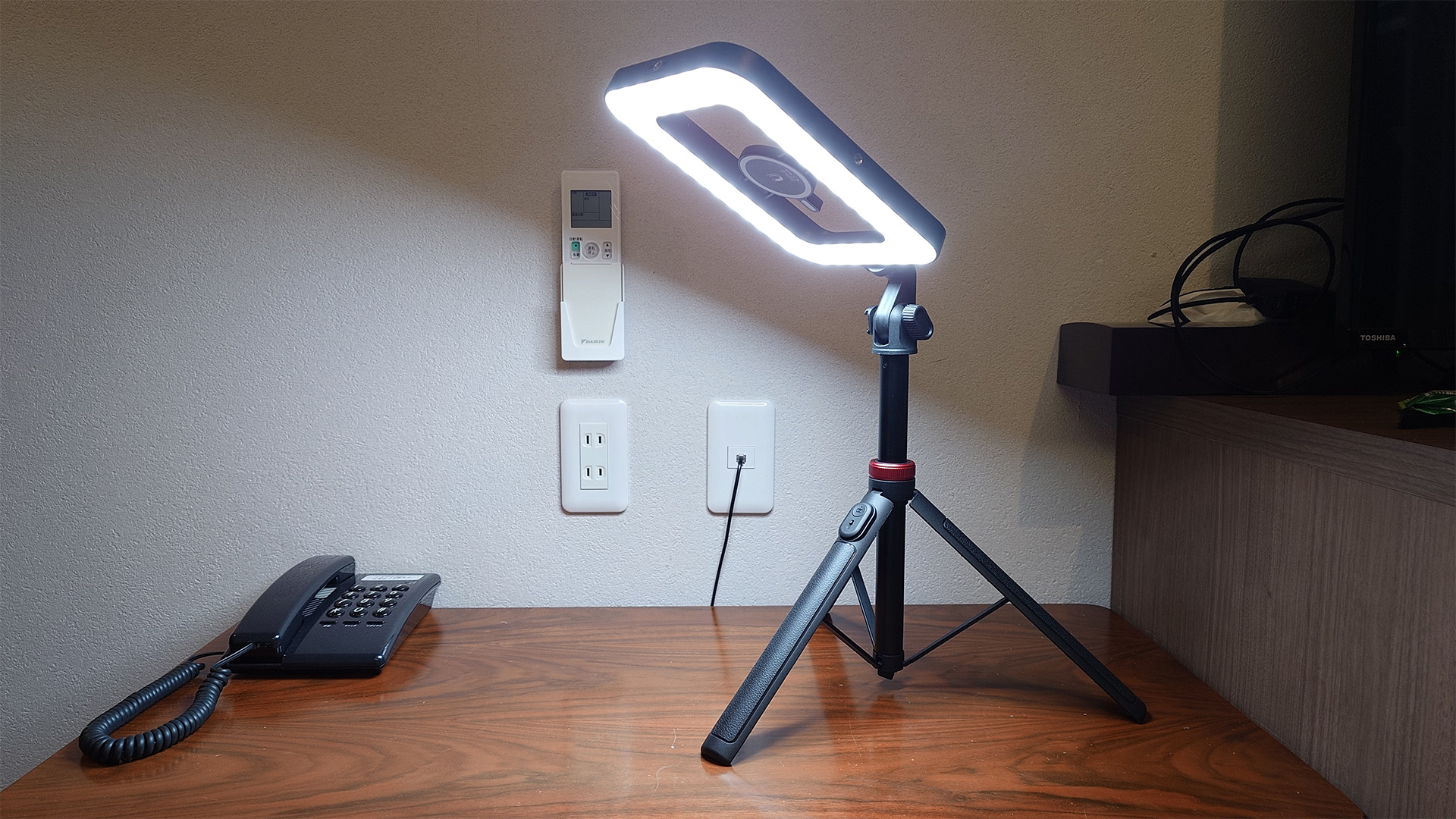 そして、ホテルの落ち着いた照度での作業や撮影を考えて、こちらのLED照明を用意しました。これはバッテリーを搭載した優れもので、中央のMagSafeにスマートフォンを固定して撮影できます。三脚にもなる自撮り延長棒も付属しており、リモコン撮影も可能です。