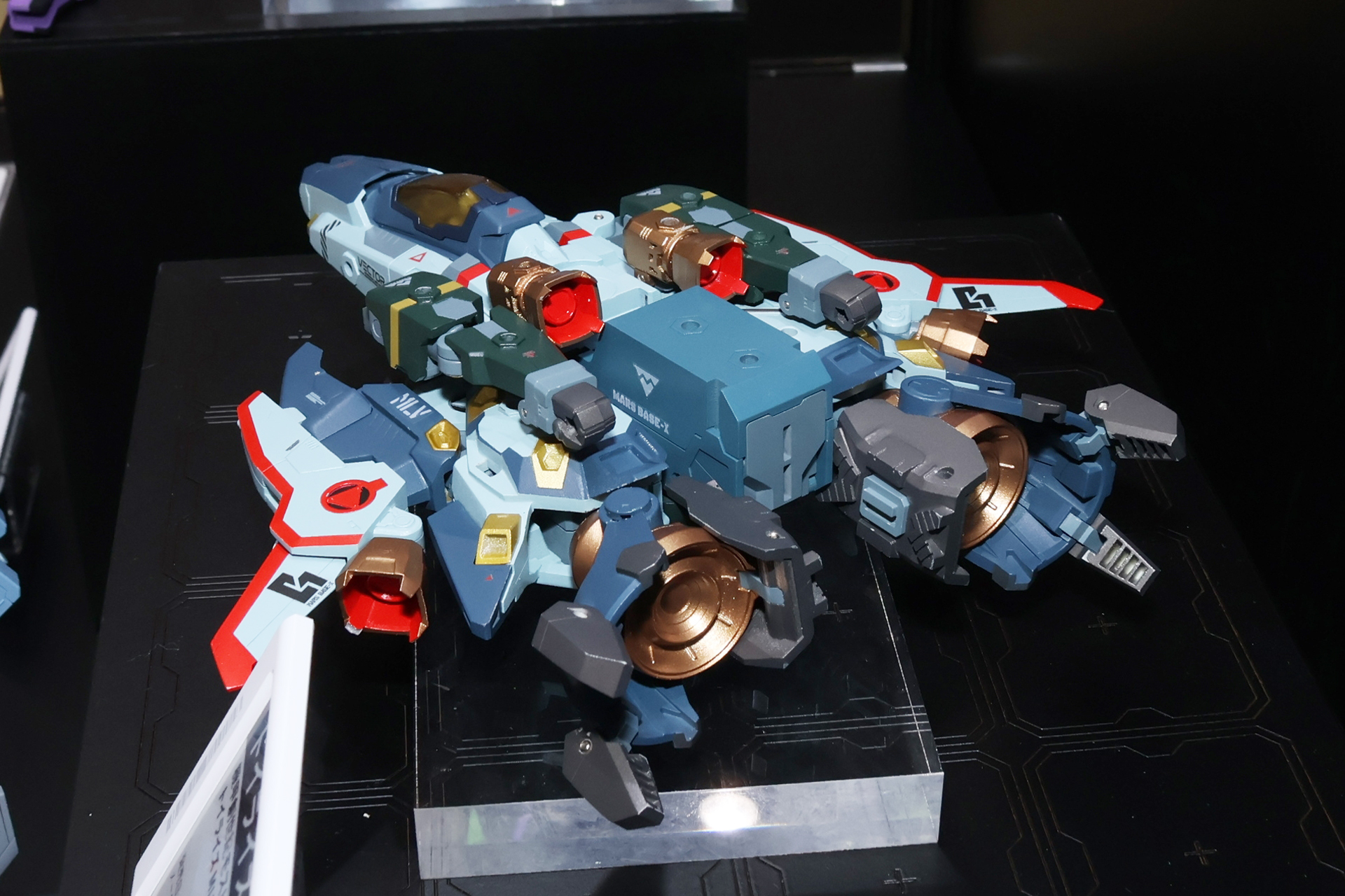展開中の3種のレギオスとはまた違ったカラーリングの機体。モスピーダのアーマーサイクルと搭乗者フィギュアも付属し、それを機体後方のコンテナに収納するギミックもある