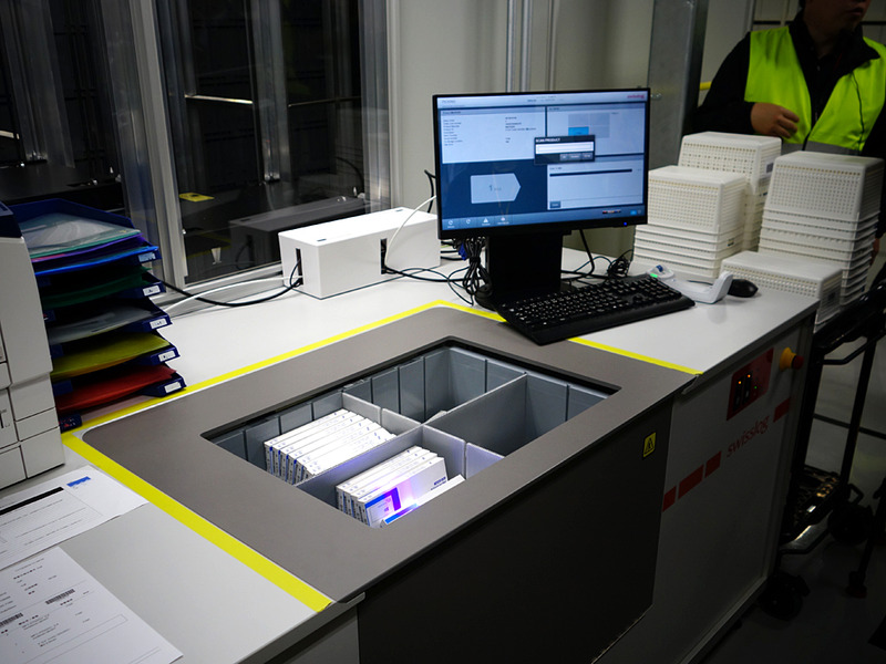 作業者のデスク。穴があいていて、そこへ次々とビンが届く