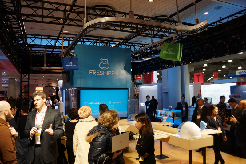 NRF 2019でのAlibabaブース。「Freshippo」の名称で盒馬鮮生のシステムが展示されており、実際にコンベアを使った動くカートのデモが披露されている