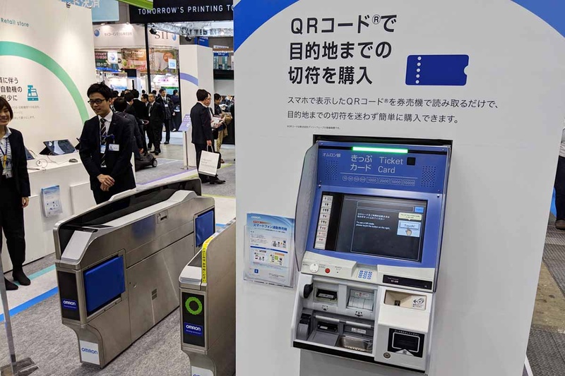 QRコードリーダーを備えた券売機を展示するオムロン。なお、改札ゲートもQRコード対応のものとなっている
