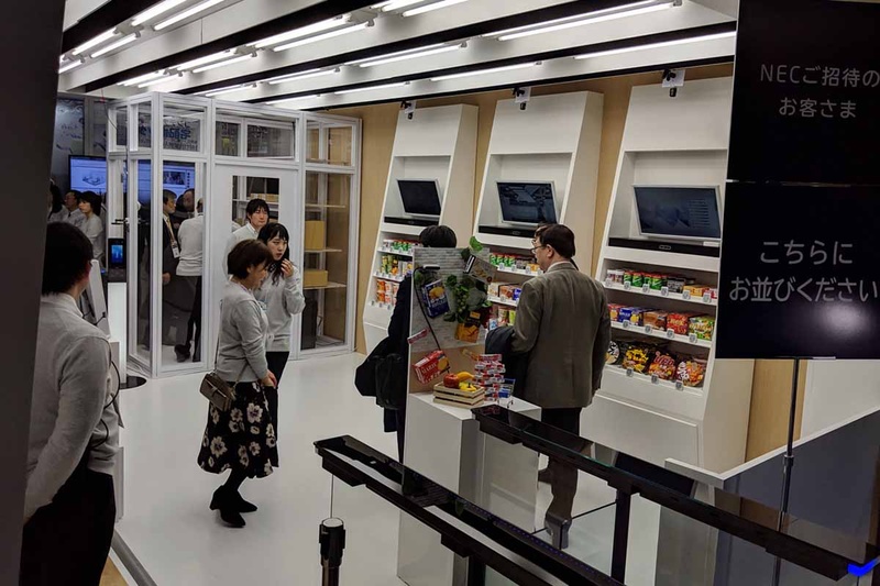 NECがデモしていたAmazon Go型の行動分析型チェックアウトフリー店舗。棚と反対側に設置された行動分析用のカメラと、棚上面に据え付けられた3台のカメラによる商品の画像認識を組み合わせることで実現する