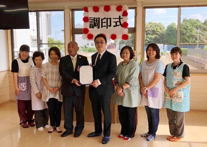 (写真中央左)中村 廣教 理事長、 (中央右)NIPPON Platform 菱木 信介氏と保育士の方々