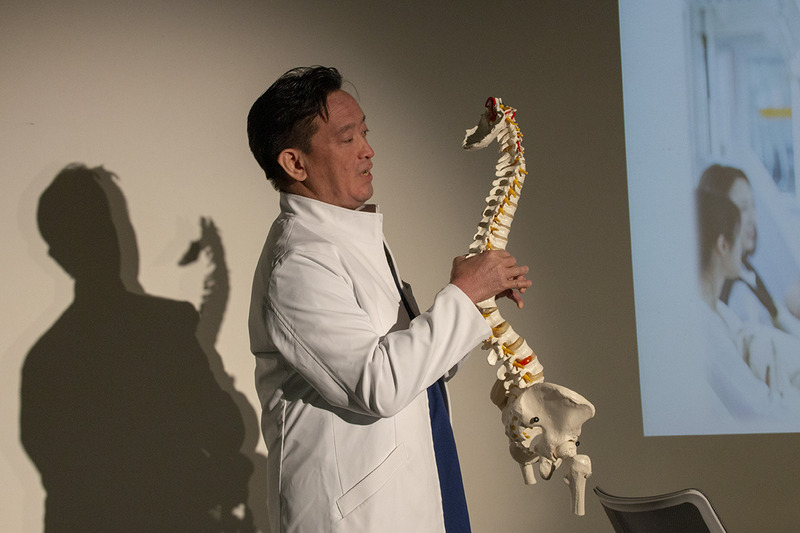 模型を用いて説明する酒井氏。模型は平常時の首から背中の様子