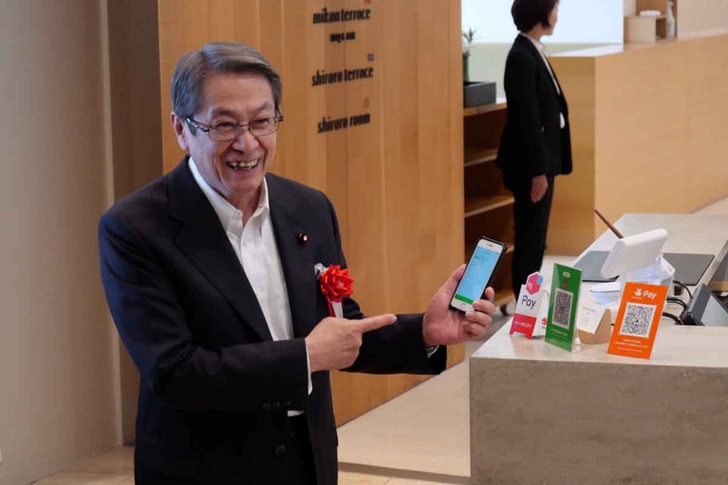 キックオフイベント終了後、実際にコード決済を体験する石田総務大臣。とても簡単で便利と評価していた