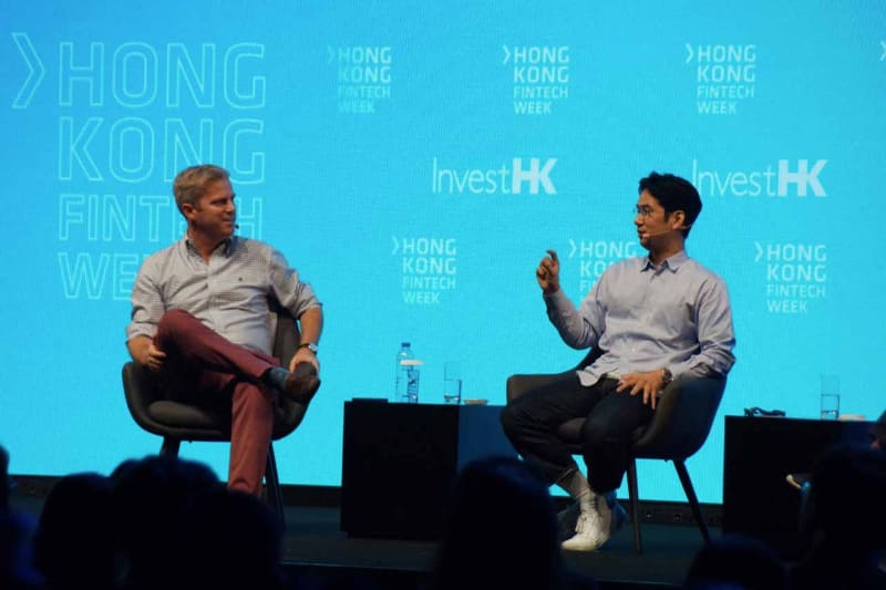 昨年11月に香港で開催されたHong Kong Fintech Weekのパネルに登場した康井氏。対談するのはEYパートナーのJames Lloyd氏と日本のキャッシュレス化の現状について話す