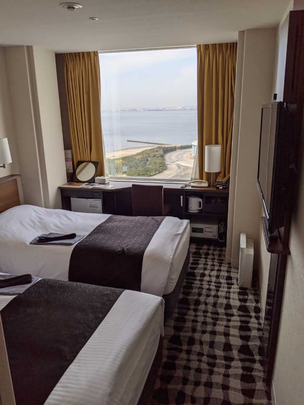 今回割り当てられた部屋。オーシャンビュー……ではなく、ベイビューの25階のツインルーム。ツインにした理由は、テーブルが窓向きになっており外の景色を楽しめるため