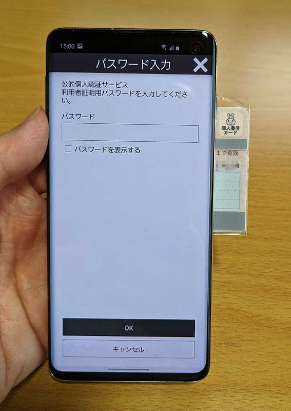 パスワード入力を求められるので、ここでは数字4桁の「利用者証明用電子証明書暗証番号」を入力。マイナンバーカードには全部で4種類の暗証番号・パスワードがあるので、間違えないように！ また、入力中もマイナンバーカードはそのまま動かさないこと