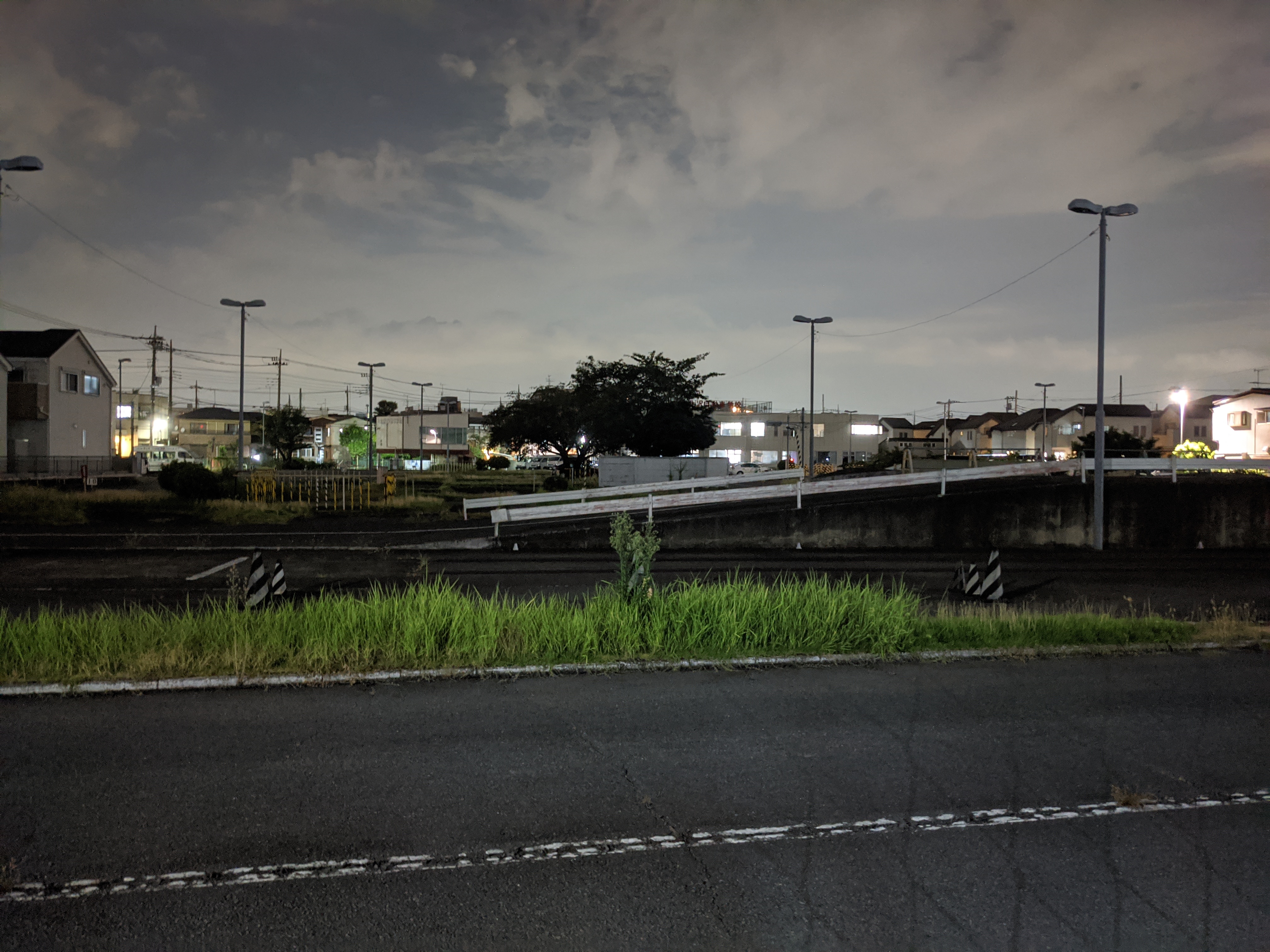 夜景モード。アスファルトの質感や窓の明かりの中の情報がかなり残っている