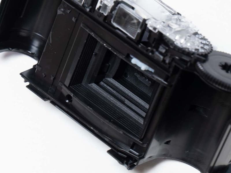 フィルムのガイドは、長辺方向に湾曲しています。これにより像面湾曲(平面が平面に写らない状況)を抑えています