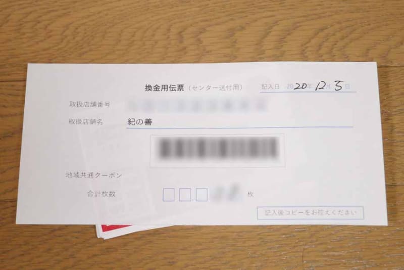 枚数を数えて用紙に枚数を記入し、その用紙と一緒に地域共通クーポンを輪ゴムで縛る