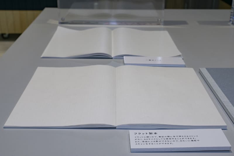 手前がフラット製本、奥が一般的なノート