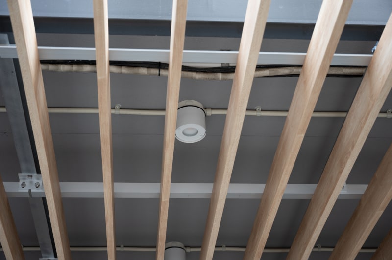 ルーバー(羽板)の裏に配管や照明。夜間は以前よりも明るくなったと好評という