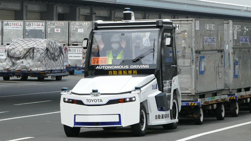 自動運転であることを示すために手を挙げてもらっている