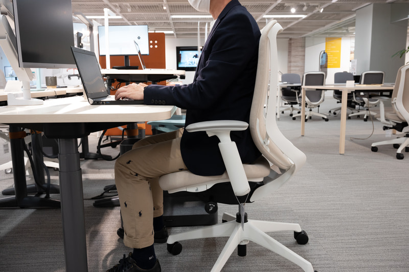 良い姿勢。かかとが接地し、背中と背もたれに隙間がなく、頭の重量を体幹で支持する。シルフィーは写真のように座面と背もたれを連動させて前傾姿勢にでき、腹部の圧迫感を軽減、ノートPCなど下向きがちな作業もある程度サポートできる