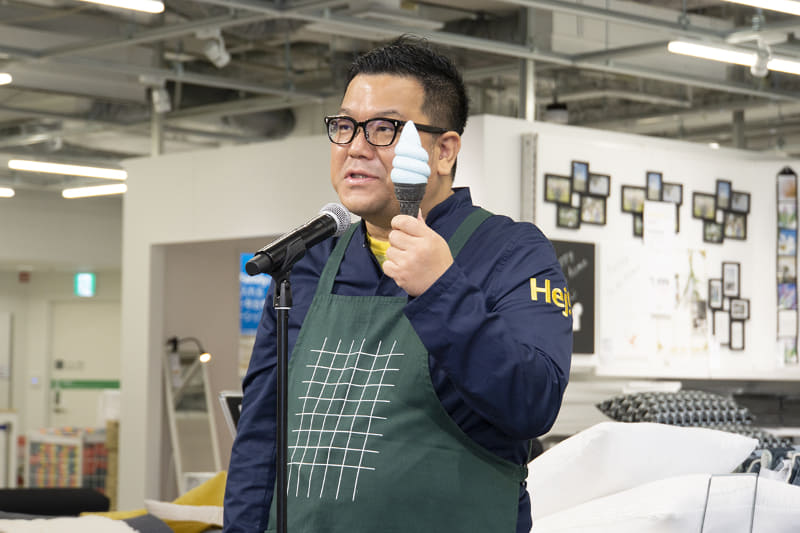 青のプラントベースアップルソフトを手にスウェーデン バイツの説明をする、イケア・ジャパン Country Food Manager 佐川季由氏