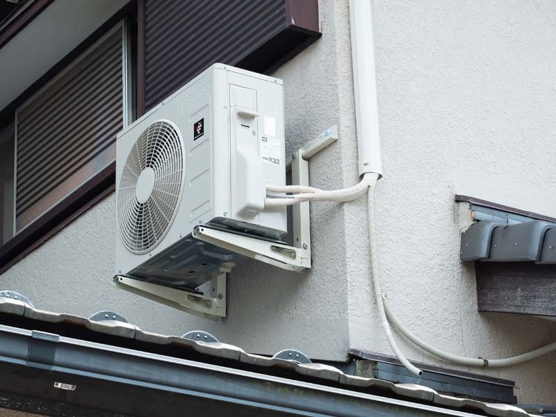 二階の作業部屋に設置したエアコンです。室外機は、外壁に金具を付け、そこに取り付けています。日が当たりづらい北東向きの壁にしました。専用コンセントのための線は、エアコンのダクトの穴から外壁に出て一階へ伸び、一階で再び屋内に入るようにしています