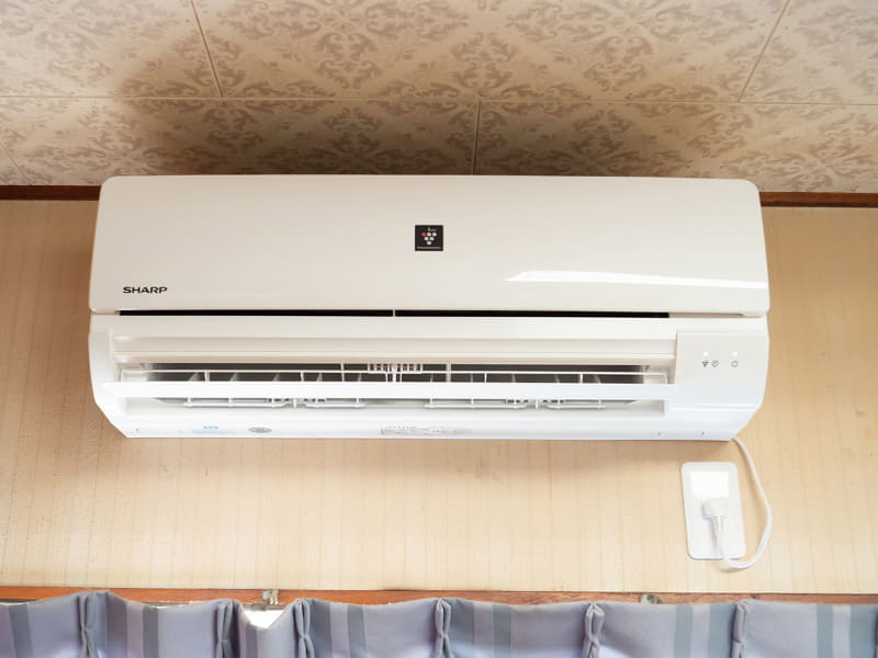 二階の作業部屋に設置したエアコンです。室外機は、外壁に金具を付け、そこに取り付けています。日が当たりづらい北東向きの壁にしました。専用コンセントのための線は、エアコンのダクトの穴から外壁に出て一階へ伸び、一階で再び屋内に入るようにしています