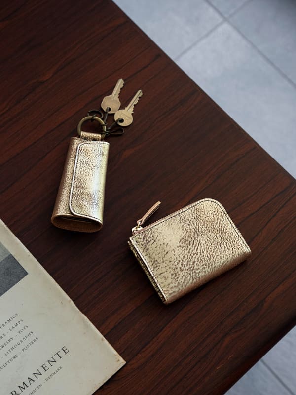 (左)ゴールド クリッピングキーケース、(右)ゴールド ハンディLファスナー