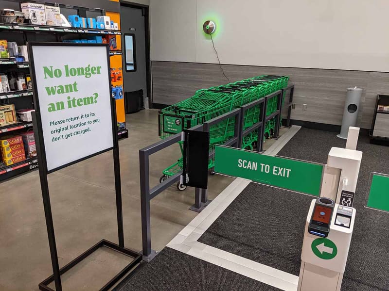 出口の注意書きとして、棚に戻した商品はカートに入っていないものとして課金されないことが示されている