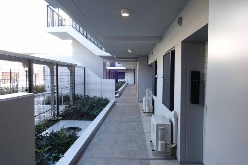 共有部廊下。集合玄関を通らないと入れないエリアだが、室外機がたくさんある