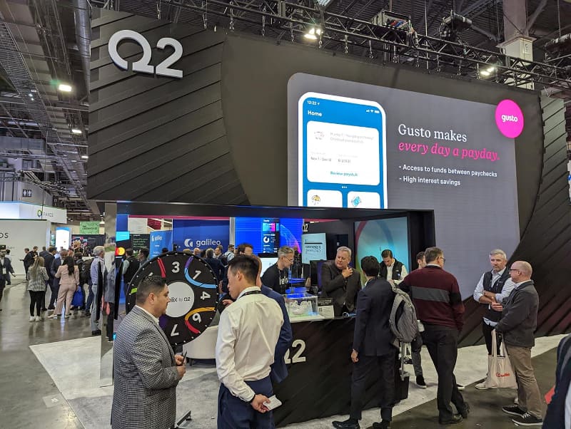 米ネバダ州ラスベガスで10月後半に開催された「Money20/20」でのQ2ブース。同社のBaaSである「Helix by Q2」の機能を組み込んだ事例としてPayroll管理ソリューションの「Gusto」が紹介されている。これにより、雇用者はGustoアプリ内からHelixの出入金サービスや普通預金口座、デビットカードなどが利用できるようになる