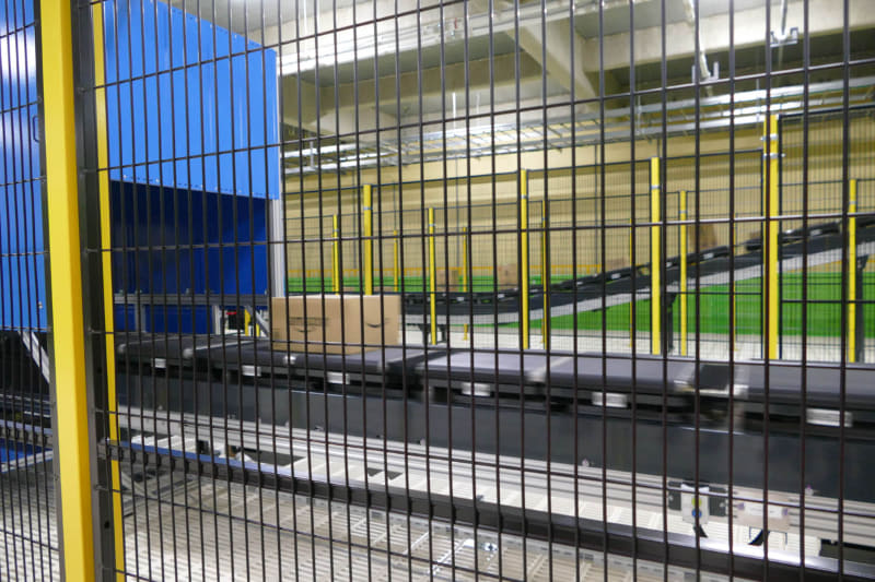 ラベルを貼った商品が流れていくクロスベルトソーター