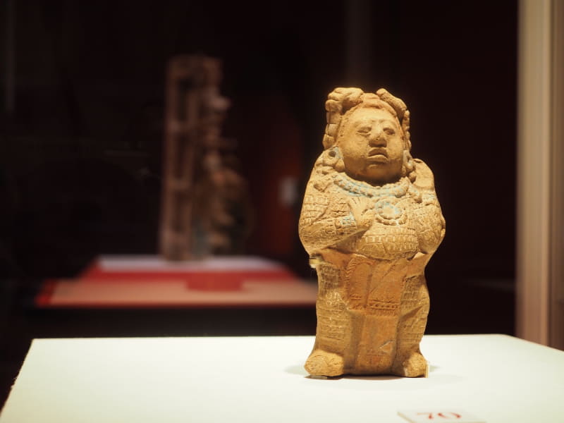 《道化の土偶》は、綿入れのような防具を装着し、儀礼的な格闘を行なった道化師と思われるそう。カントン宮殿から出土し、ユカタン地方人類学博物館蔵。背後にあるのは《香炉台》