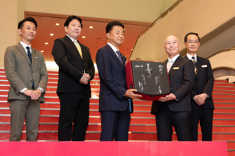 音楽祭に出演したアーティストのサインが入った記念の椅子が野村不動産の松尾社長に贈呈された(展示場所は現在未定)