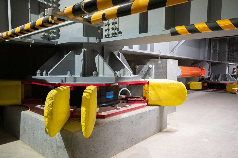 ビル地下にある免震構造。右のオレンジ色のシリンダーは制振ダンパー