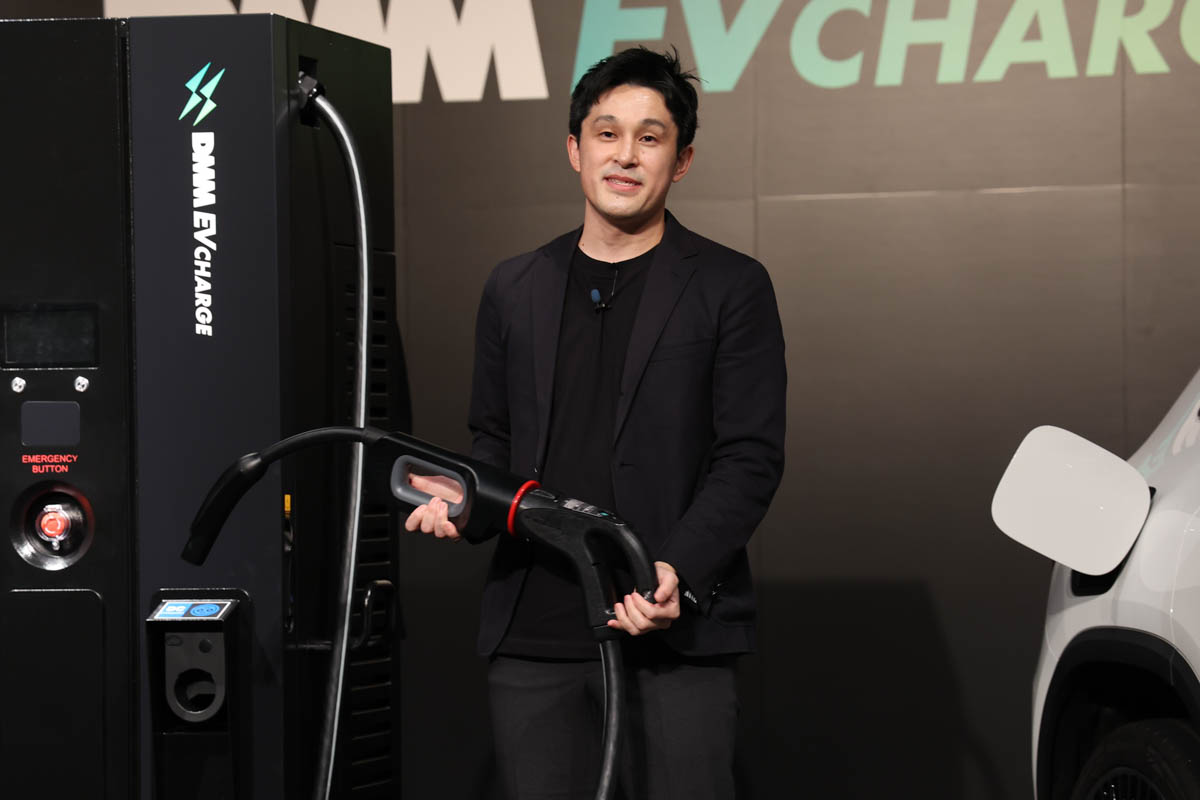 CHAdeMOをNACSに変換するコネクタ。デモを行なったのはDMM EV CHARGE事業部 事業部長の板垣良太氏