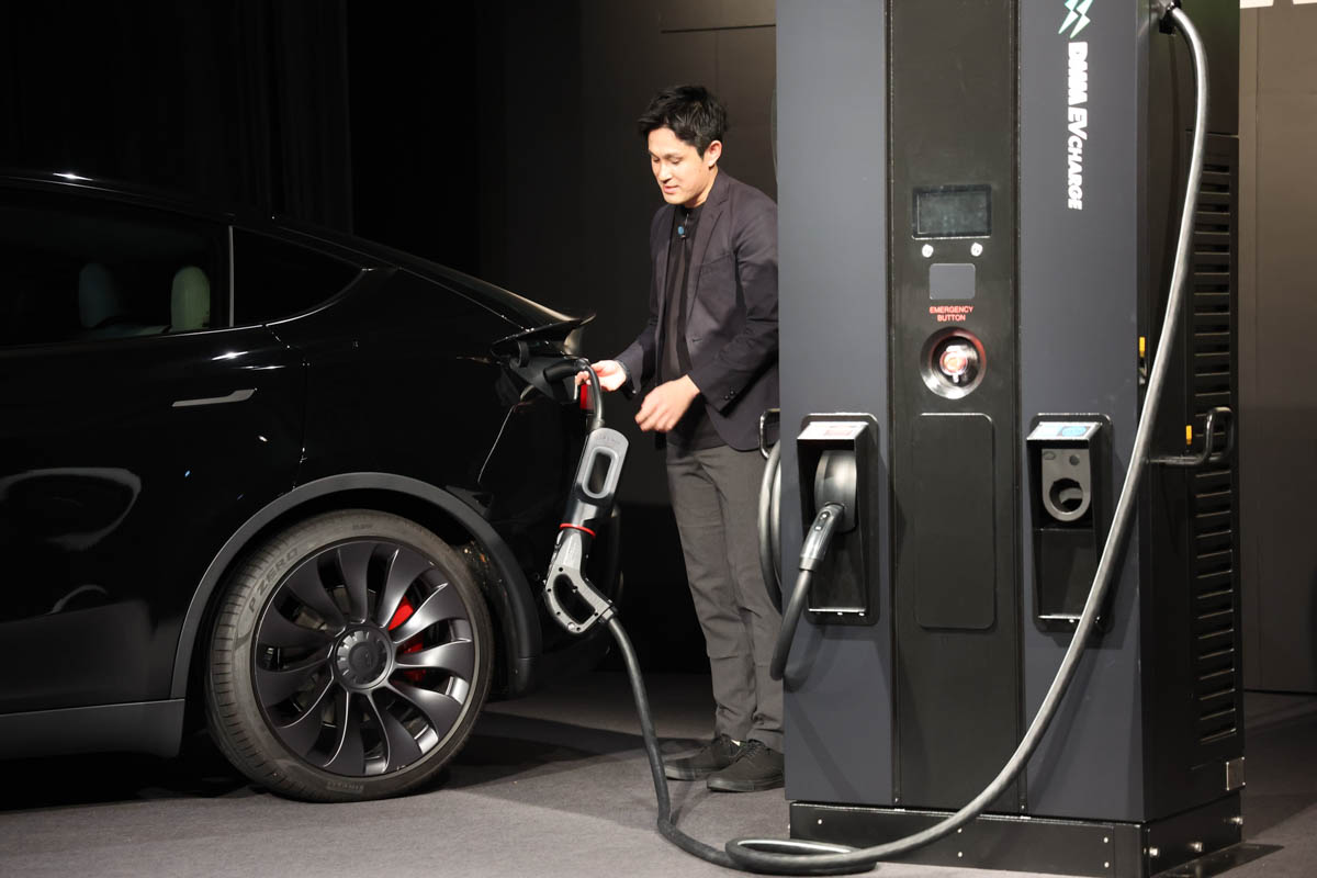 CHAdeMOをNACSに変換するコネクタ。デモを行なったのはDMM EV CHARGE事業部 事業部長の板垣良太氏