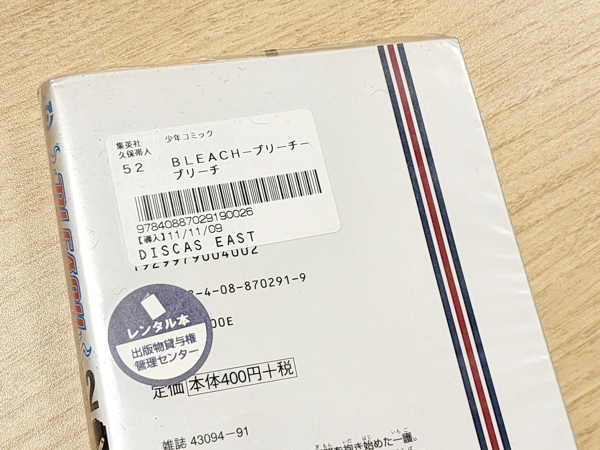 レンタル本のシールが貼られており、表紙とは別にカバーもされています。黒い毛みたいなのは入っていた黒い袋の繊維です