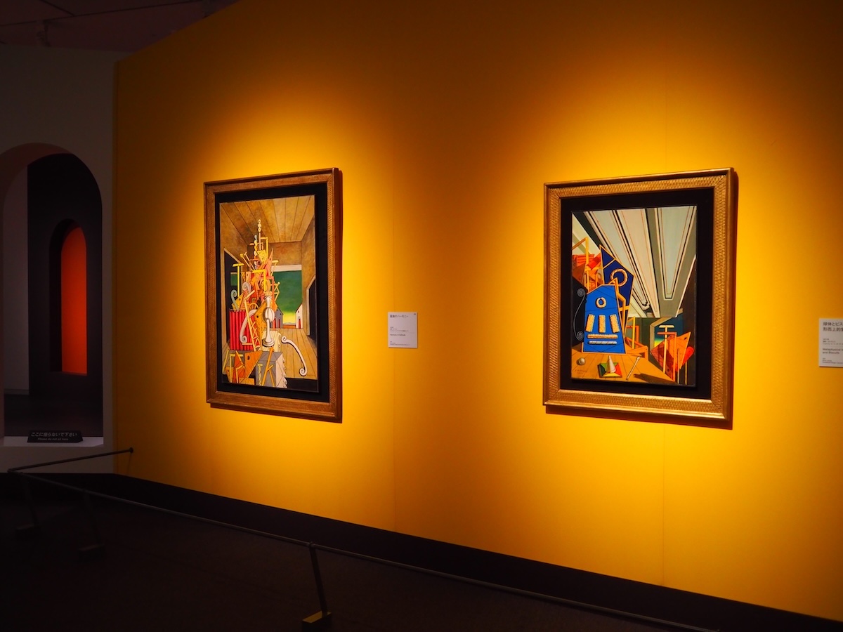 展示風景より。1971年に描かれた《球体とビスケットのある形而上的室内》と、1976年に描かれた《孤独のハーモニー》。いずれもジョルジョ・エ・イーザ・デ・キリコ財団(ローマ) (C)Fondazione Giorgio e Isa de Chirico, Roma