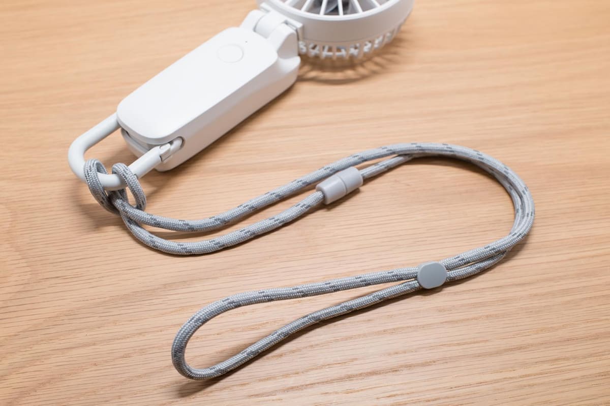 付属のネックストラップを装着。長さ調節機構と安全パーツが備わる