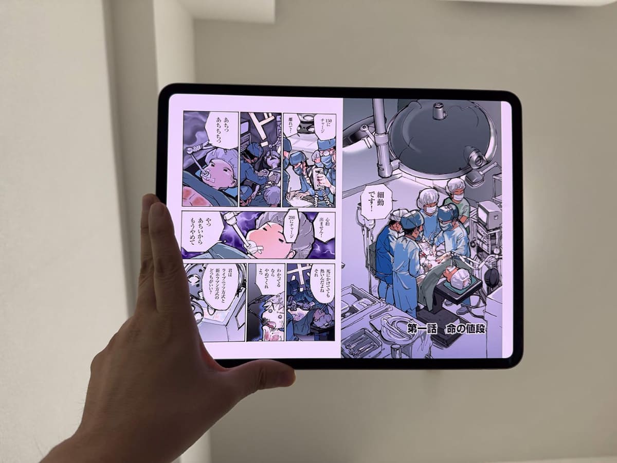 仕事場で寝転がり、iPad Proを手で持って本を読む感じを再現して写真を撮ってみた。表示しているコミックは鈴木みそ氏の「銭」。著者より許諾を得て利用