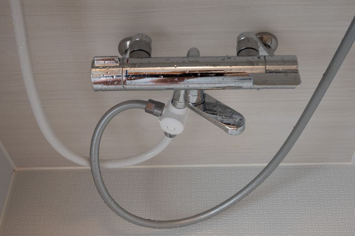 水流切替器部分。グレーのホースが既存のハンドシャワー用です